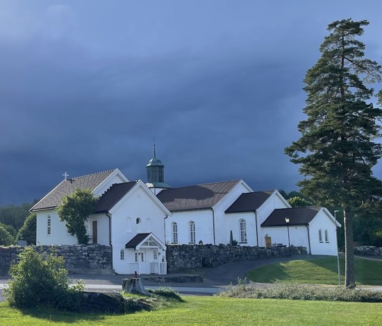 Bilde av Botne kirke med mørke skyler